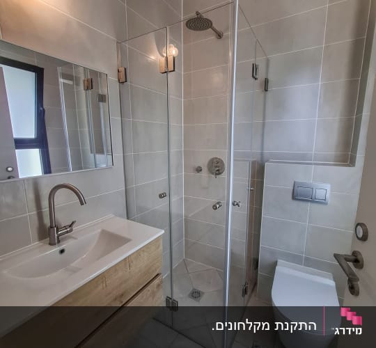 מקלחון זכוכית פינתי מותקן בחדר רחצה מודרני